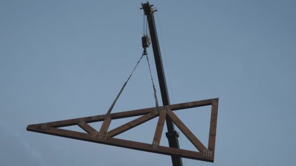 Bouwwerkzaamheden. Installatie van een houten truss op het dak van een particulier huis. — Stockvideo