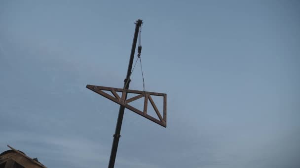 Bouwwerkzaamheden. Installatie van een houten truss op het dak van een particulier huis. — Stockvideo