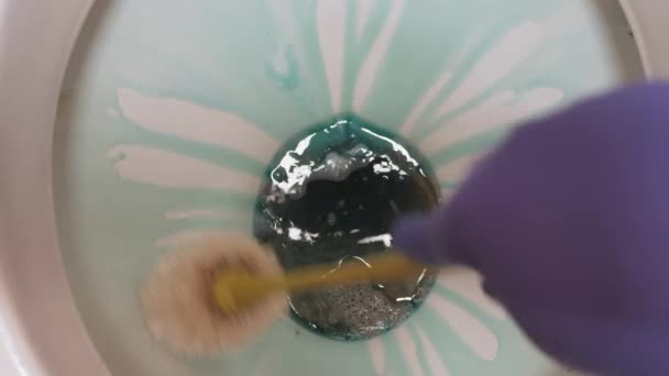 Flush water in the toilet. Cleaning the white surface of the toilet with a toilet brush. — Stock Video
