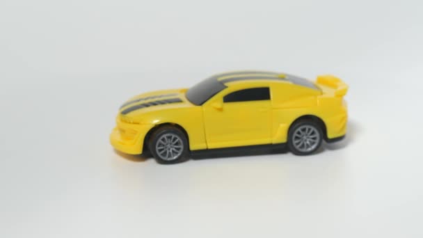おもちゃの車の被写体撮影。黄色のスポーツカーのモデルは回転テーブルの上にあります. — ストック動画