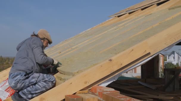 Travaux de toiture. Installation d'isolation pour l'isolation du toit d'une maison privée. — Video