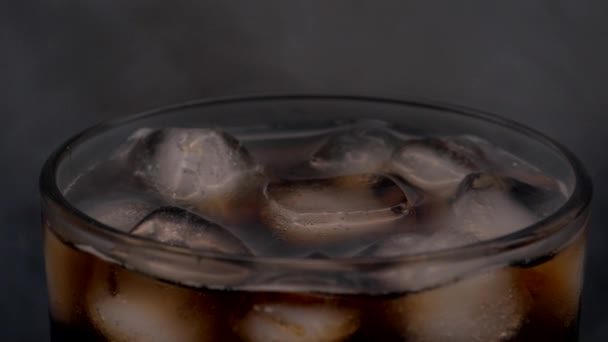 Eisgläser werden mit Sodawasser gefüllt. Dunkle kohlensäurehaltige Getränke mit Eiswürfeln übergießen. Den Hintergrund mit Rauch füllen. — Stockvideo