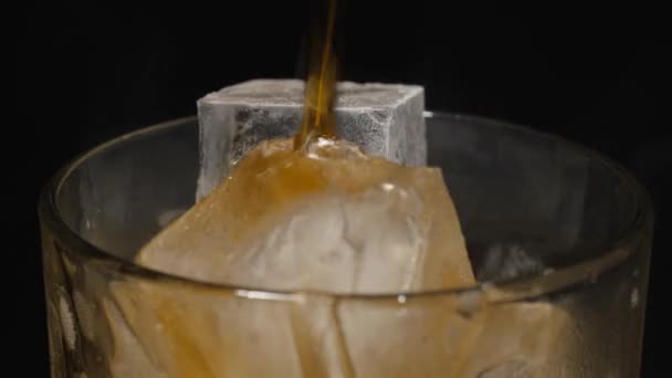 Eisgläser werden mit Sodawasser gefüllt. Dunkle kohlensäurehaltige Getränke mit Eiswürfeln übergießen. — Stockvideo