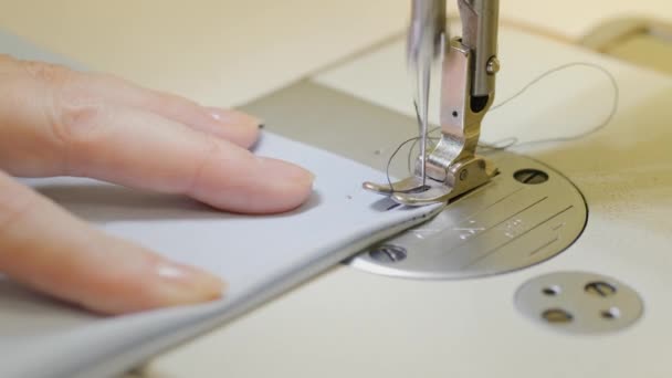 Taller de costura. Mujer cosiendo en una máquina de coser industrial. Manos de cerca. Conexión de dos piezas de tela. — Vídeo de stock