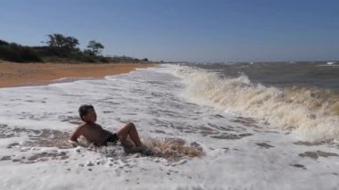 Deniz tatilindeki çocuk duyguları. Genç bir dalga tarafından kaplandı..