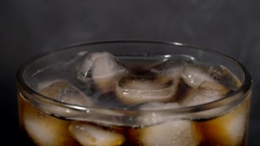 Buzlu bardak soda ile doludur. Buzlu koyu karbonatlı içecekler. Arka plan dumanla dolduruluyor.