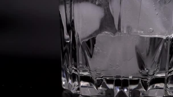 Es batu dalam gelas pada latar belakang hitam. — Stok Video