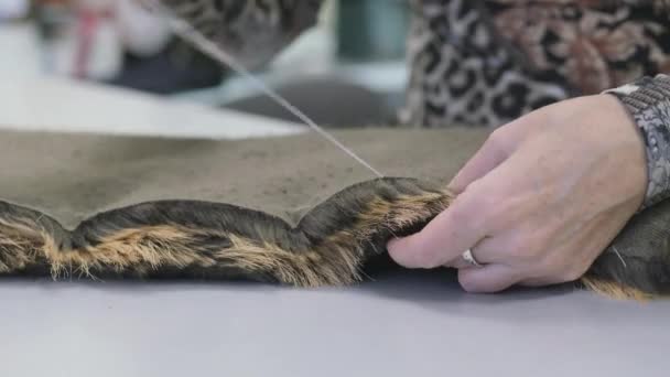 Taller de costura. Coser dos piezas de piel sintética a mano. Costura con aguja e hilo. — Vídeo de stock