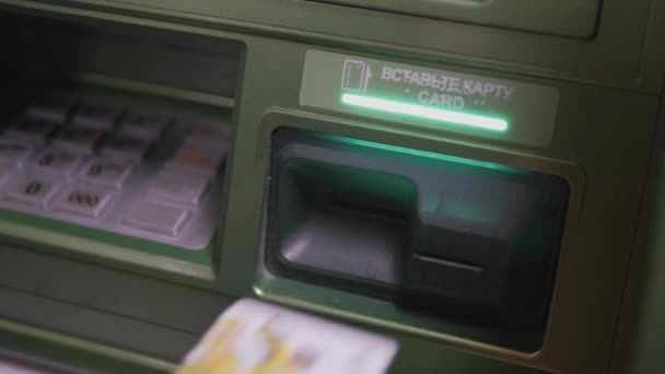 Retirer de l'argent d'un distributeur. L'enfant retire de l'argent du distributeur. INSCRIRE LA CARTE. CARD. MIR. SBERBANK. — Video