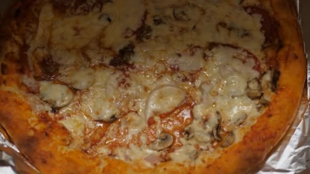 Grande pizza ronde avec un côté fromage dans une boîte. — Video