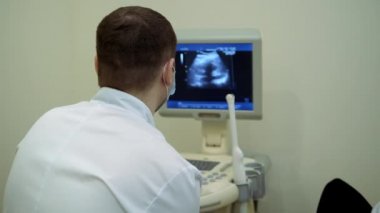 Sağlık kontrolleri. Ultrason cihazı üzerinde çalış, ultrason muayenesi. Sensör karın boyunca hareket ediyor..