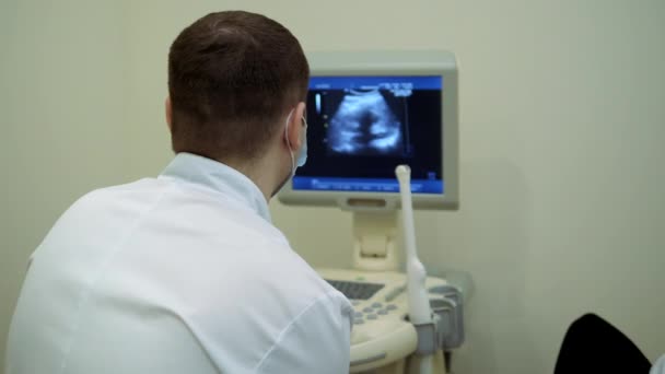 Diagnostyka zdrowia. Praca nad urządzeniem do diagnostyki ultradźwiękowej, badanie ultrasonograficzne. Czujnik porusza się wzdłuż brzucha.. — Wideo stockowe