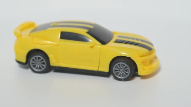 Sujeto de disparo de un coche de juguete. Un modelo de un coche deportivo amarillo está en una mesa giratoria. — Vídeos de Stock