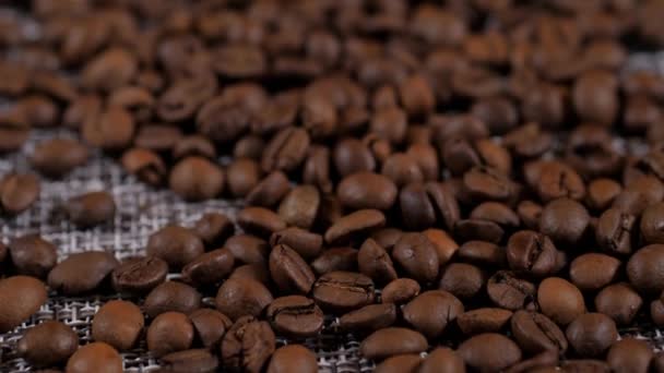 탁자 위에 있는 커피 콩. 볶은 커피 원두로 이루어진 배경. — 비디오