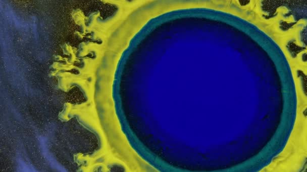 Goccia di blu in giallo, una goccia di vernice che cresce sull'oro nebbioso. Spazi profondi. — Video Stock