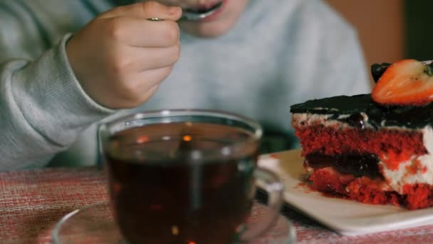 Meisje eet dessert met verse aardbeien en drinkt thee. Kind glimlacht zoet tijdens het eten. — Stockvideo