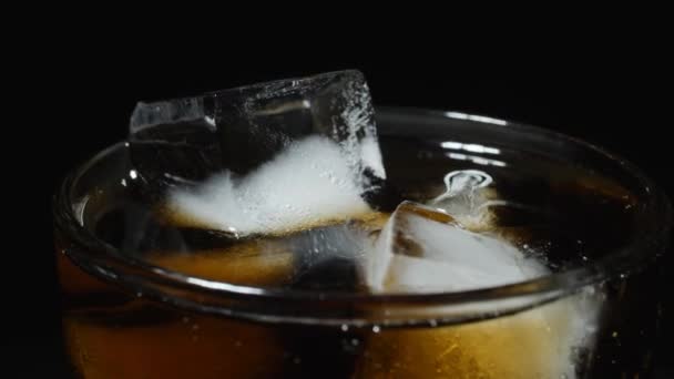 IJsglas is gevuld met fris water. Giet donkere koolzuurhoudende dranken met ijsblokjes. — Stockvideo