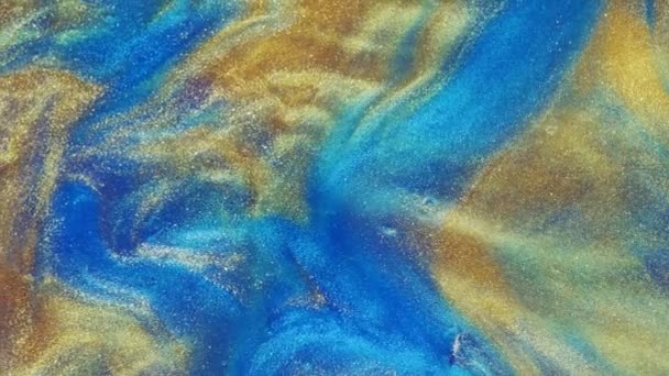 Arte fluida. astrazioni liquide. Polvere d'oro stellata. Ruscelli astratti di colore rosso vivo e pastello chiaro con polvere d'oro sparsa sul piano su fondo blu. Struttura in marmo. — Video Stock