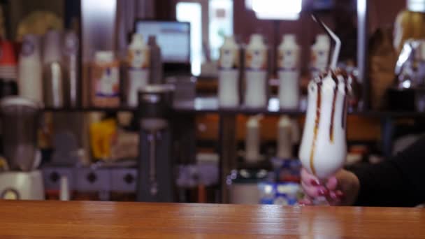 Milkshake met slagroom in een groot glas. Zoete druppels siroop druppelen door het glas. — Stockvideo