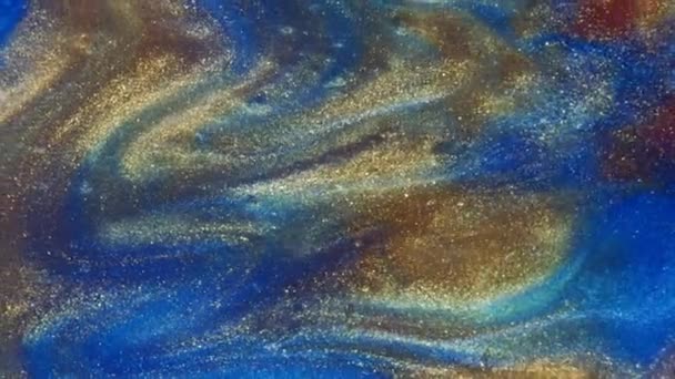 Fluid art. Liquid abstractions. Starry gold dust. Abstract bright red and light pastel streams with gold dust spread across the plane on a blue background. Marble texture. — Stock Video