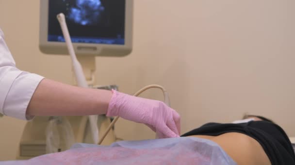 Diagnósticos de salud. Trabajo en un dispositivo de diagnóstico por ultrasonido, examen por ultrasonido. El sensor se mueve a lo largo del abdomen. — Vídeo de stock