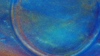 Akışkan sanat. Sıvı soyutlamalar. Yıldızlı altın tozu. Soyut parlak kırmızı ve açık renkli pastel akıntılar, uçağın her tarafına mavi bir zemin üzerine yayılmış altın tozları. Mermer dokusu.