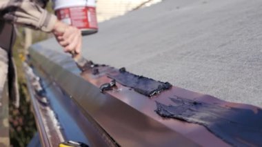 Bituminous mastic ile dikişlerin kokusu. Yumuşak bir çatı yapmak için hazırlık. Çatı, özel bir evde işe yarar..