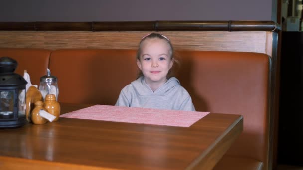 Das kleine Mädchen bekommt ein Dessert mit frischen Erdbeeren und Tee auf einem Tablett serviert. Kellnerjob. — Stockvideo