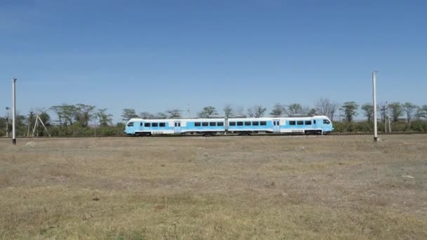 Синій поїзд іде між селами на Кримському півострові.. — стокове відео