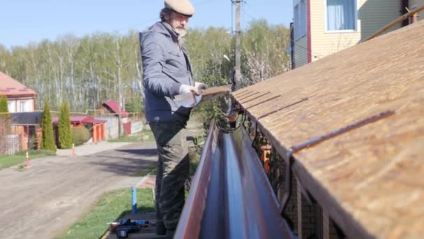 Montáž okapu. Střecha pracuje v soukromém domě. — Stock video