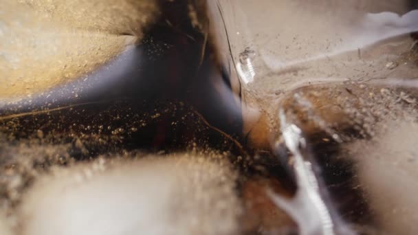 Χύσιμο Cola με παγάκια από κοντά. Cola με πάγο και φυσαλίδες σε γυαλί. — Αρχείο Βίντεο