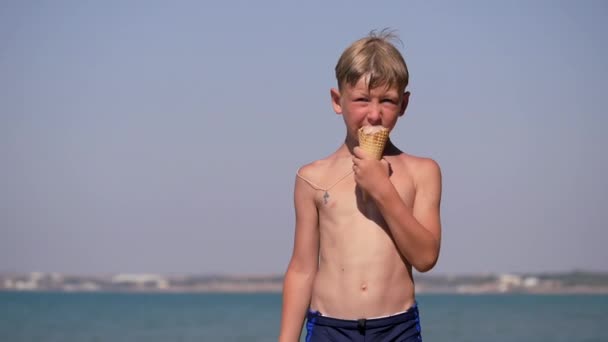 Chico en la playa comiendo helado y dando un pulgar arriba. — Vídeo de stock