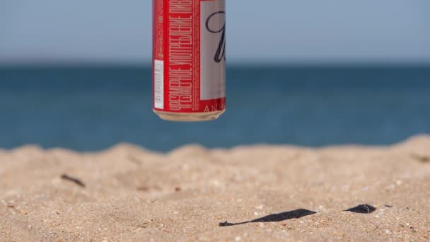 Bier. Blechbüchsen fallen auf den feinen Sand. EXZESSIVE VERBRAUCHUNG VON BIER IST HARMFUR GESUNDHEIT. — Stockvideo