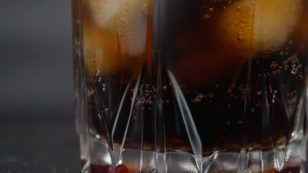 Ledové sklo je naplněno sodovkou. Nalévání tmavých sycených nápojů s kostkami ledu. — Stock video