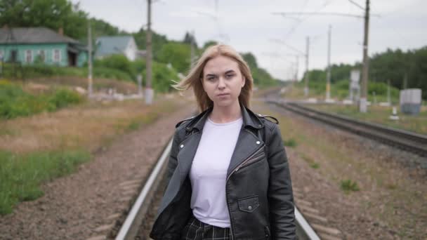 Young woman walks on the rail of the railway tracks. — Stock Video