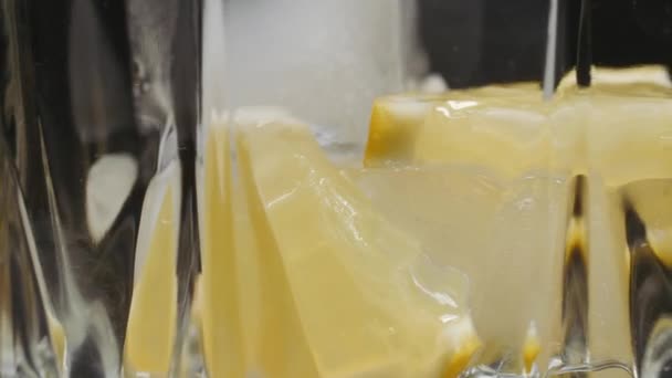 Primer plano de agua de vidrio con lima, limón. Soda con rodajas de limón y hielo para desintoxicar. concepto de frescura. — Vídeos de Stock