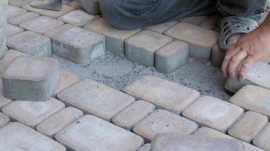 İnşaat işi. Yaya evlerinin kaldırımlarını döşemek, taşları yayalara dizmek. Kaldırımın kurulumu.