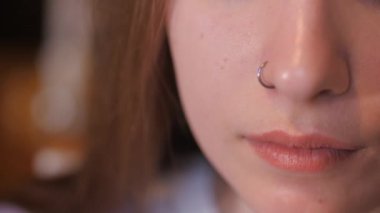 Gülümse. Diş telleri dişlere takılı. Kadın dudaklarına köpüklü bir kupa kahve getiriyor ve bir yudum alıyor. Kız geniş bir şekilde gülümsüyor.