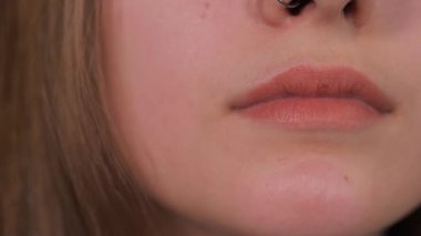 Kadın alt dudağını ısırıyor. Yakın plan.