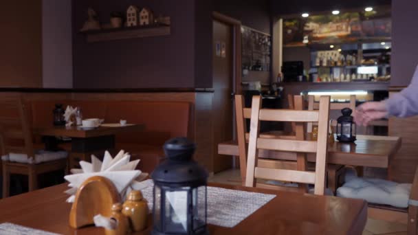 Mädchen setzt sich an einen Tisch in der Cafeteria. — Stockvideo