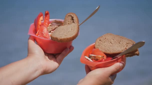 Trozos de carne fritos sobre carbones con verduras y un trozo de pan en platos rojos, sobre el fondo del mar. — Vídeo de stock