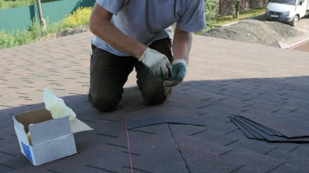 Dakbedekking. Leggen van een zacht tegelelement op de plaat. Installatie van het dak aan de voet. — Stockvideo