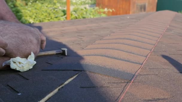 Acoperişuri funcţionează. Montarea unui element de țiglă moale pe creasta acoperișului și instalarea acestuia. Instalarea acoperișului la bază . — Videoclip de stoc