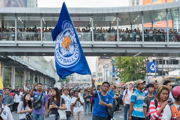 Supporter waves the Leicester City FC flag while waiting the parade