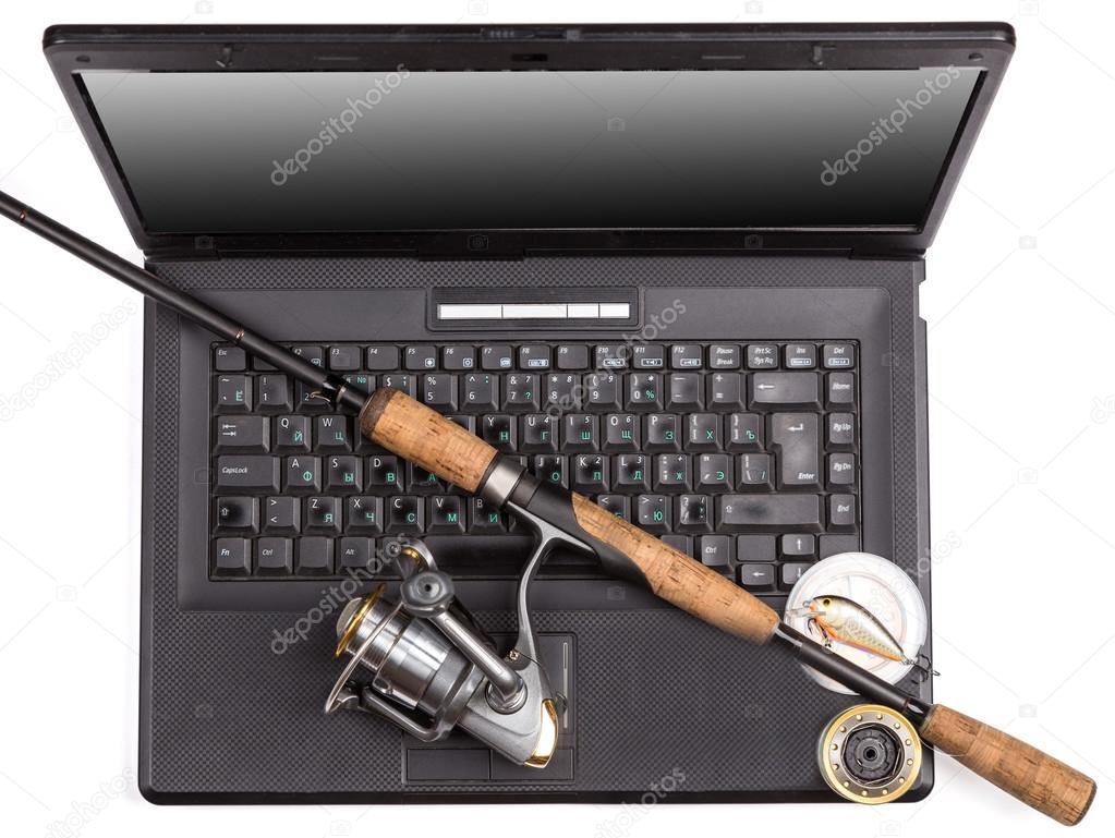 fishing tackles on keyboard a black notebook