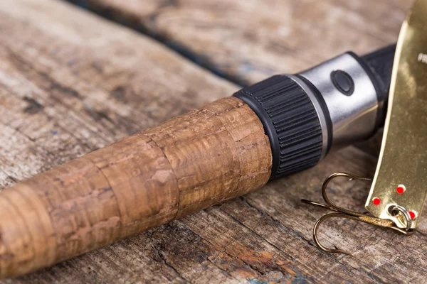 Handle of fishing rod with lure on wooden — Stock Photo, Image