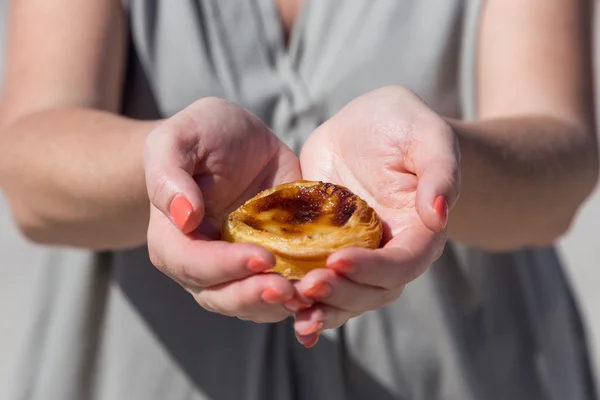 Portugalski deser Pasteis de nata w ręce kobiety — Zdjęcie stockowe