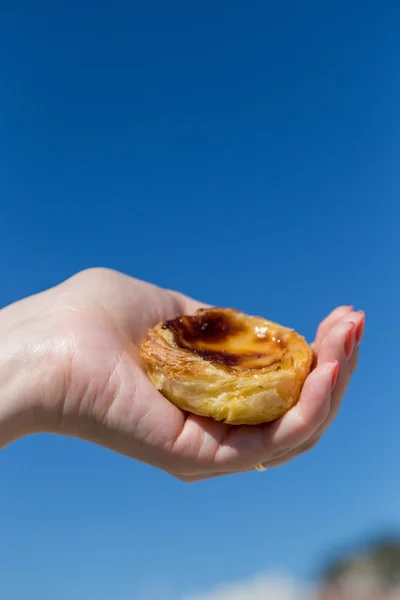 Portugalski deser Pasteis de nata w ręce kobiety — Zdjęcie stockowe