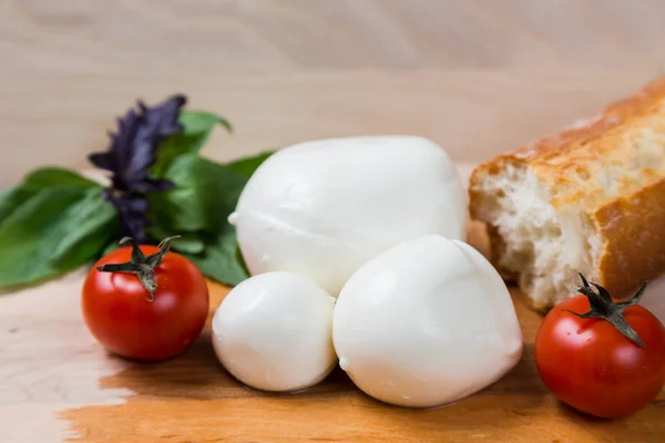 Kule różnej wielkości mozzarella z pomidorami cherry, chleb i — Zdjęcie stockowe