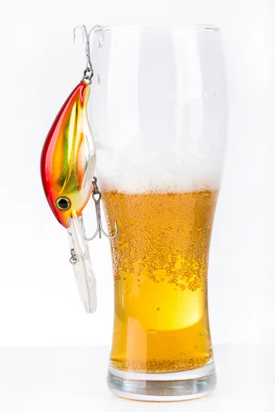 Рыболовецкие приманки возле стекла с пивом — стоковое фото